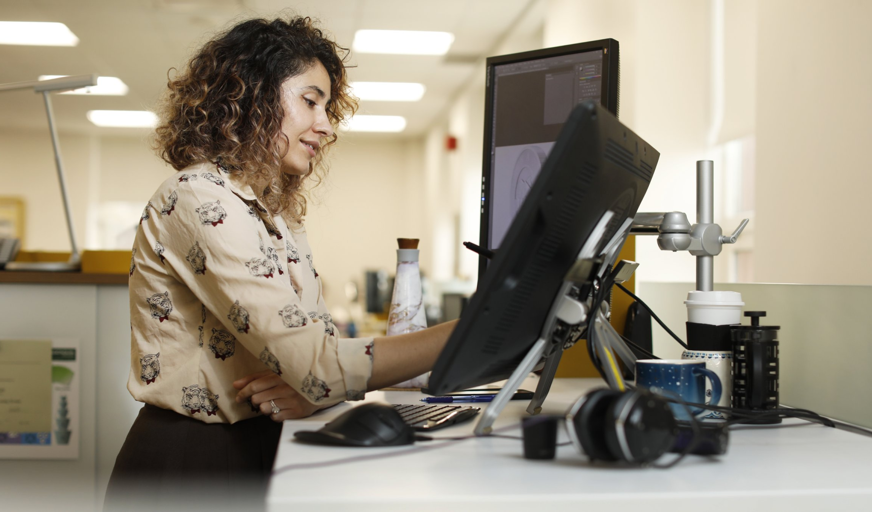 Photo of woman working at her standing desk. Photo of woman working at her standing desk.