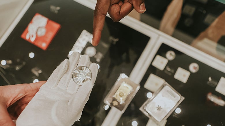 Person inspecting a coin Person inspecting a coin